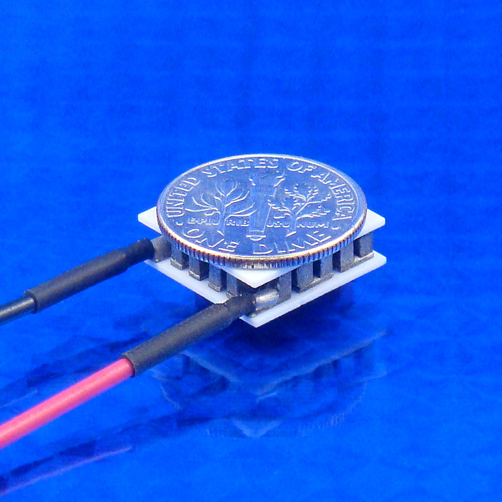 Small TEC with a dime coin on top against a blue background